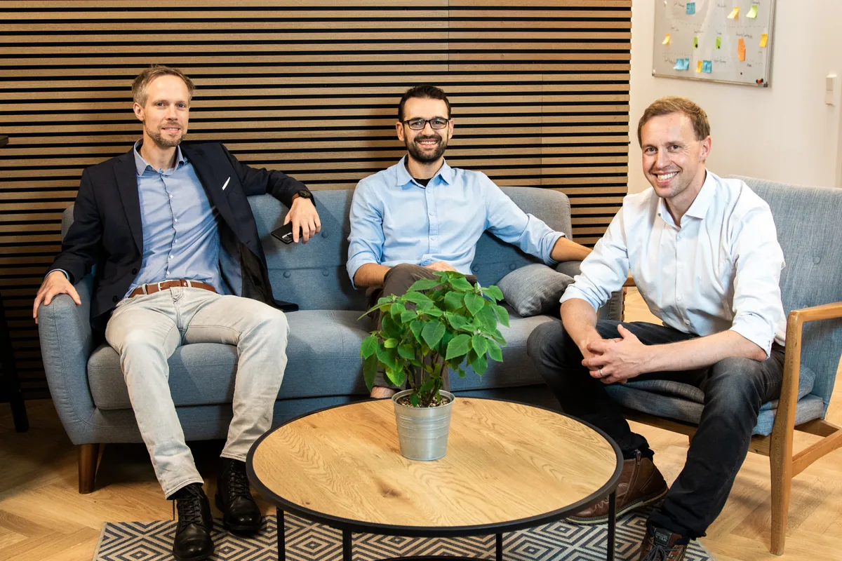 André Torkler, Matthias Stokowy und Matti Biskup sitzen auf einem Sofa im Büro